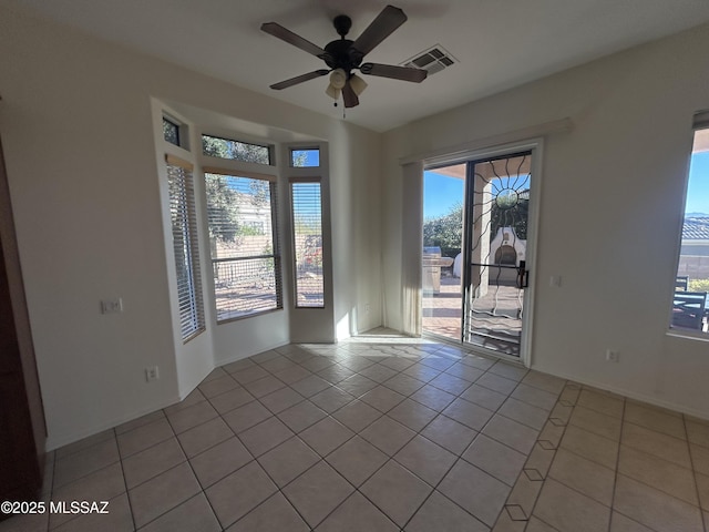 empty room with a ceiling fan, visible vents, and light tile patterned flooring