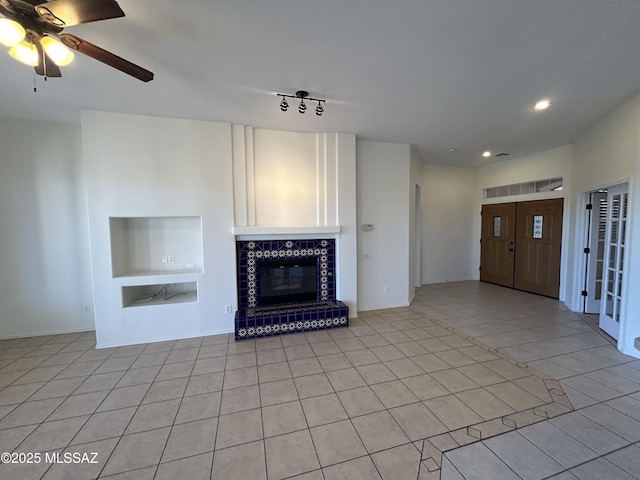 unfurnished living room featuring light tile patterned floors, ceiling fan, built in shelves, recessed lighting, and a glass covered fireplace