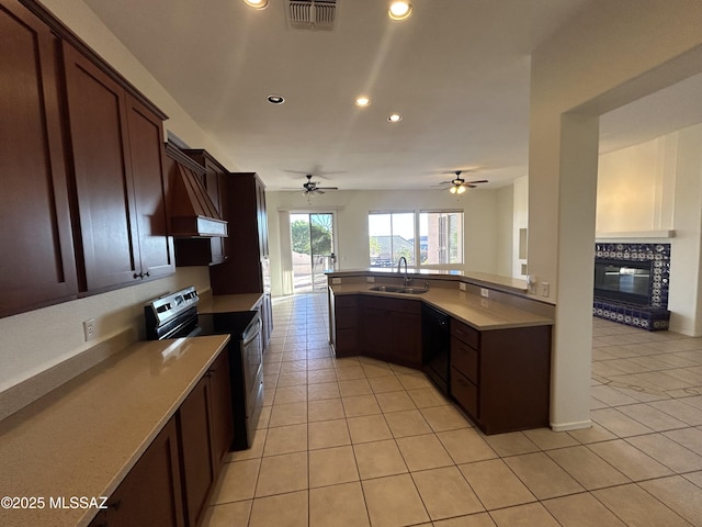 kitchen featuring light tile patterned flooring, a sink, visible vents, black dishwasher, and stainless steel range with electric stovetop