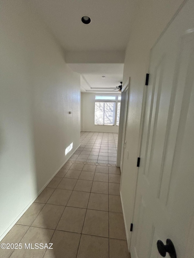 hallway featuring baseboards and tile patterned floors