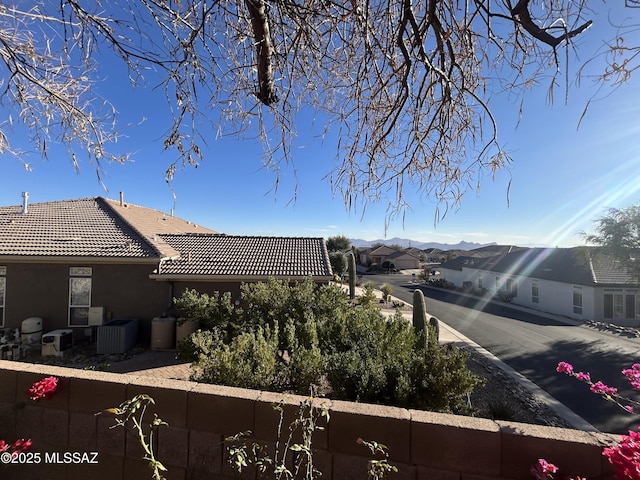 view of side of property featuring a tile roof, cooling unit, and stucco siding