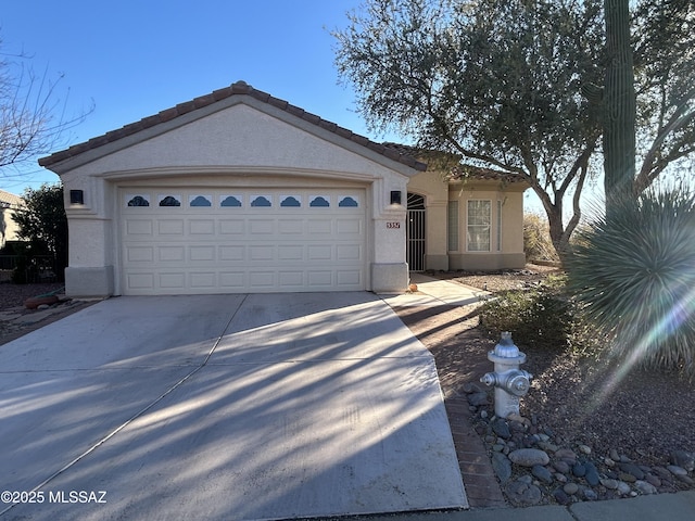 ranch-style home with a garage, concrete driveway, a tiled roof, and stucco siding