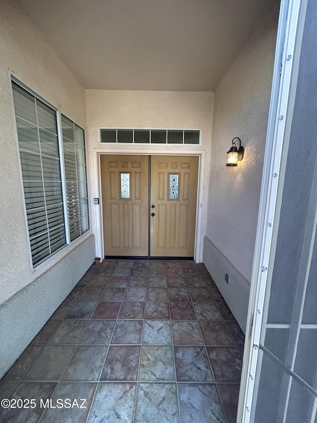 entrance to property featuring stucco siding