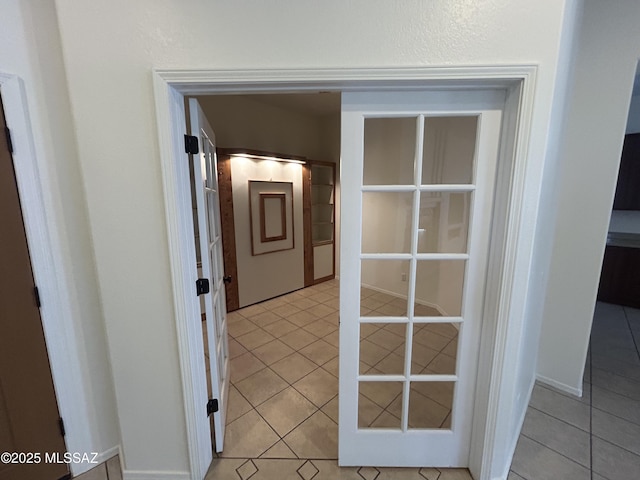 hall with light tile patterned flooring and baseboards