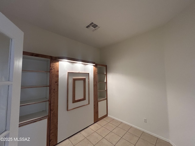 unfurnished bedroom with visible vents, baseboards, and light tile patterned flooring