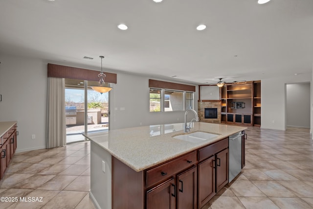 kitchen featuring visible vents, a glass covered fireplace, open floor plan, a sink, and stainless steel dishwasher