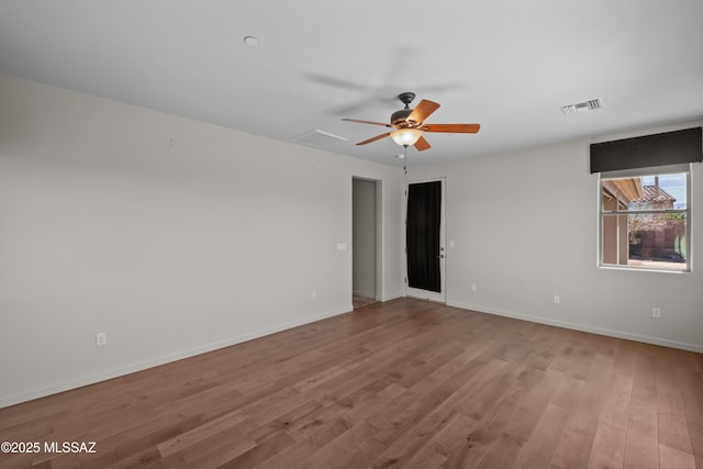 empty room with visible vents, baseboards, and wood finished floors