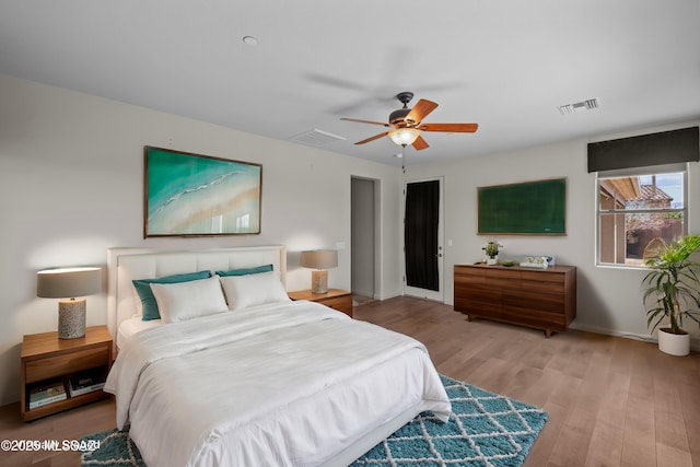 bedroom featuring light wood-style floors, ceiling fan, and visible vents