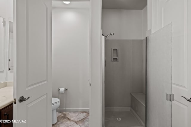 bathroom featuring a walk in shower, vanity, toilet, and tile patterned floors