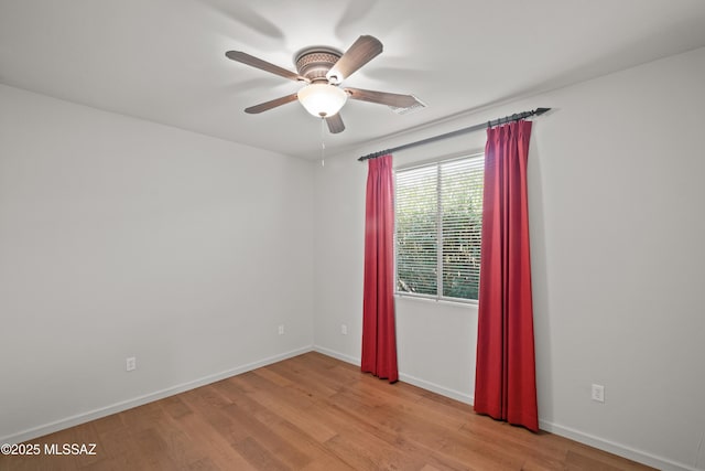 unfurnished room with baseboards, a ceiling fan, and light wood-style floors