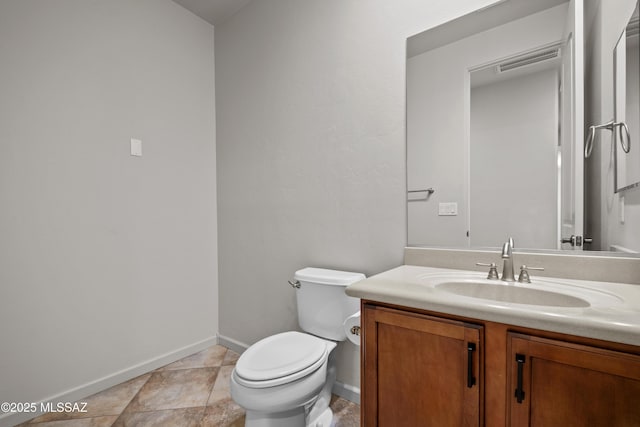 half bathroom with toilet, tile patterned flooring, baseboards, and vanity