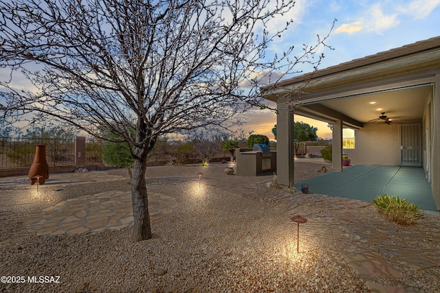 view of yard featuring ceiling fan, a patio, an outdoor kitchen, and fence