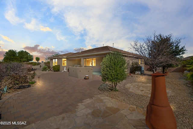 view of front of property featuring an outdoor kitchen, a patio area, and stucco siding