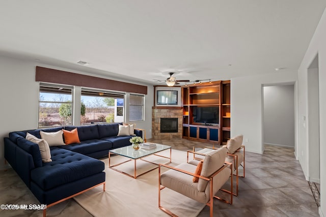 living room with visible vents, ceiling fan, and a stone fireplace