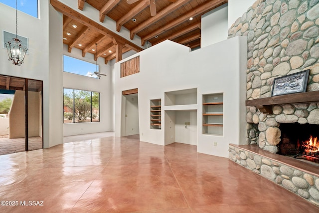 unfurnished living room with beam ceiling, a fireplace, finished concrete flooring, wood ceiling, and a chandelier