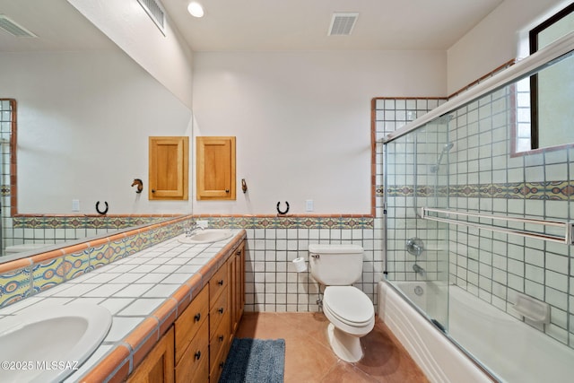 full bath featuring toilet, a sink, and visible vents