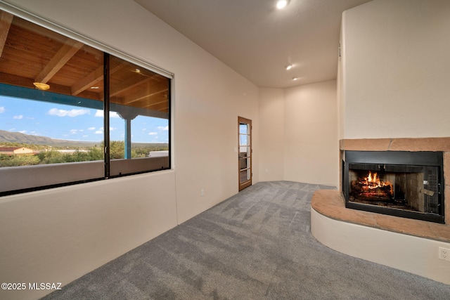 unfurnished living room with carpet flooring and a multi sided fireplace