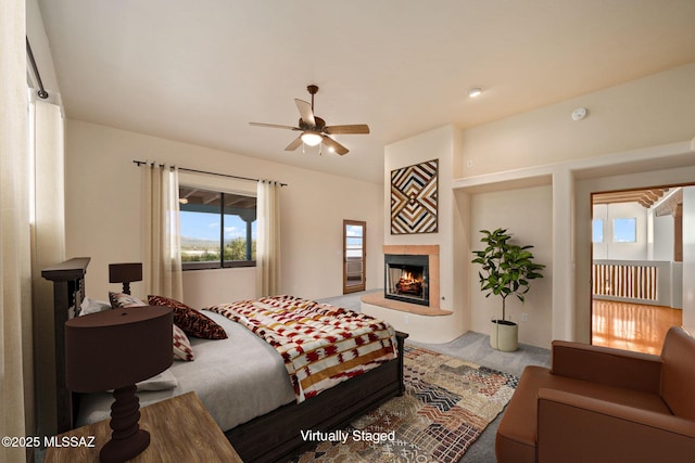 bedroom featuring a warm lit fireplace and carpet flooring