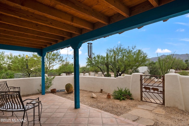 view of patio / terrace featuring a gate, fence, and a mountain view