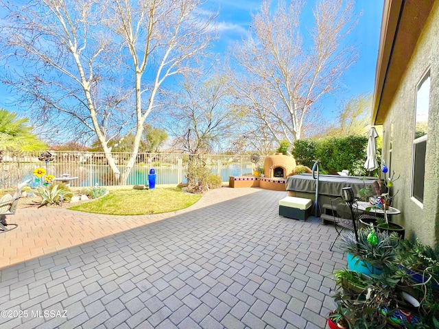 view of patio with exterior fireplace and a fenced backyard