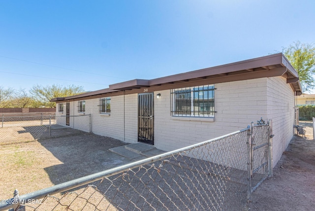 exterior space with fence and brick siding