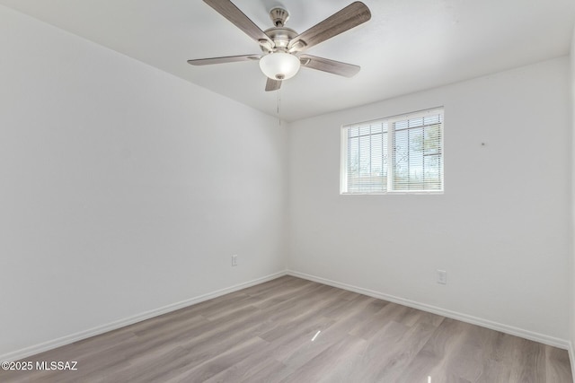 unfurnished room with baseboards, ceiling fan, and light wood-style floors