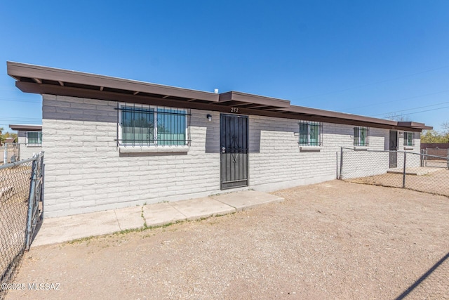 view of front of home featuring brick siding and fence