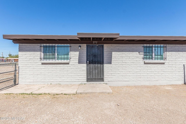 view of front of property featuring fence and brick siding
