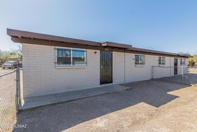 back of property featuring brick siding and fence
