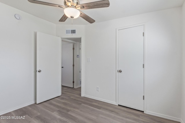 unfurnished bedroom featuring visible vents, baseboards, and wood finished floors