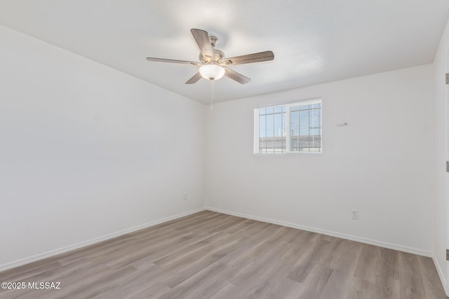 spare room with light wood-style floors, baseboards, and a ceiling fan