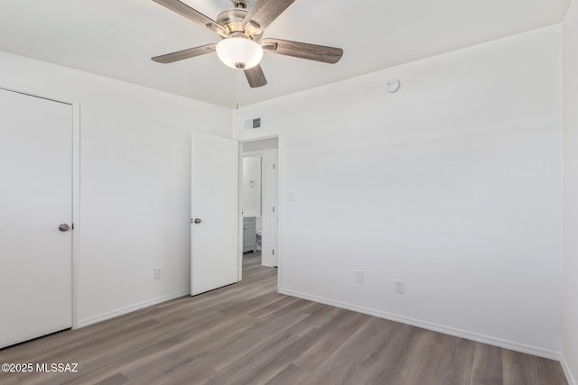unfurnished bedroom featuring baseboards, visible vents, ceiling fan, and wood finished floors