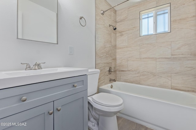 bathroom with toilet, washtub / shower combination, wood finished floors, and vanity