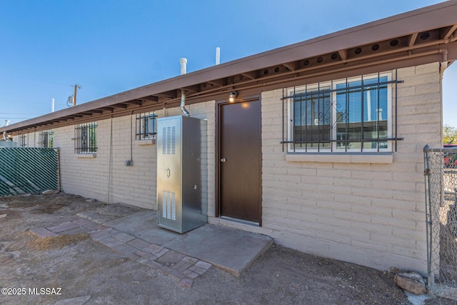 rear view of property featuring brick siding and fence