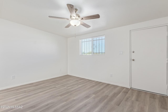 empty room with light wood-type flooring, baseboards, and a ceiling fan