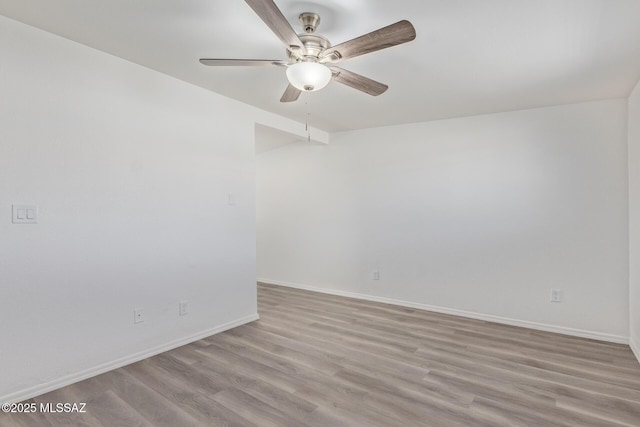 empty room with baseboards, ceiling fan, and light wood-style floors