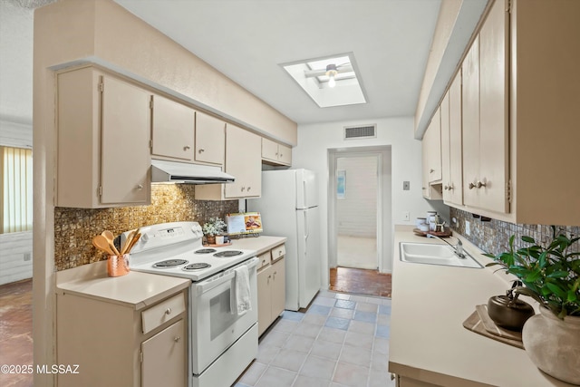 kitchen featuring white appliances, a skylight, visible vents, under cabinet range hood, and a sink