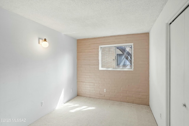 carpeted spare room with a textured ceiling