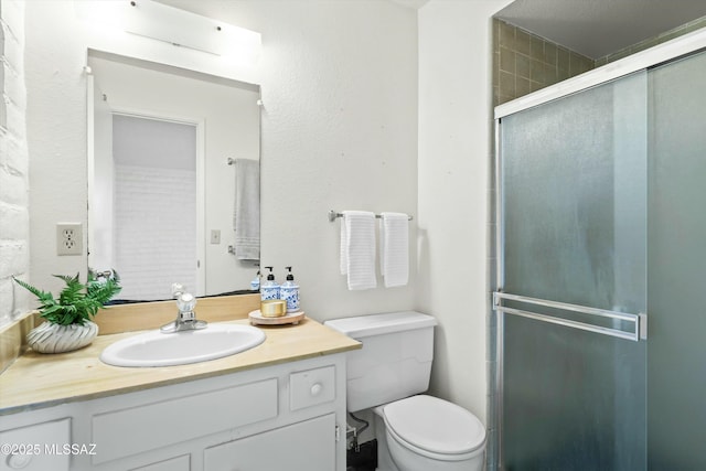 bathroom featuring toilet, a stall shower, and vanity