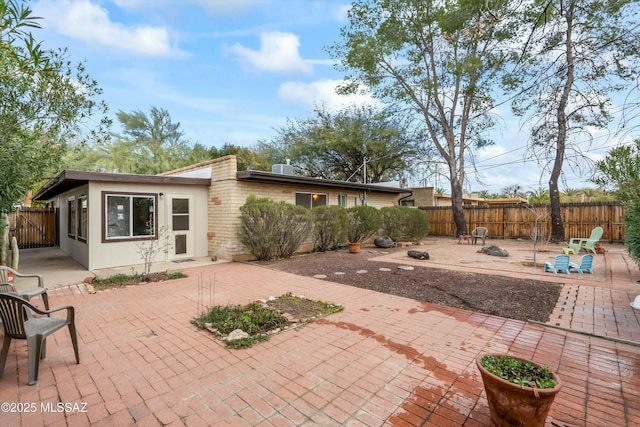 back of house featuring an outdoor fire pit, a fenced backyard, and a patio