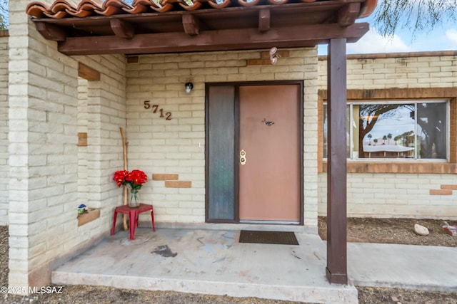 doorway to property with brick siding