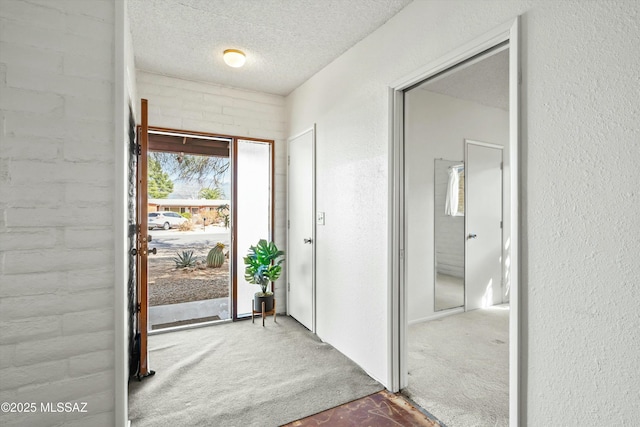 interior space featuring a textured ceiling and a textured wall