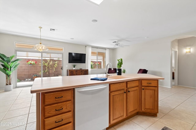 kitchen featuring light countertops, a sink, dishwashing machine, visible vents, and arched walkways