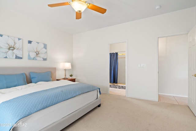 carpeted bedroom featuring baseboards, connected bathroom, tile patterned flooring, and ceiling fan