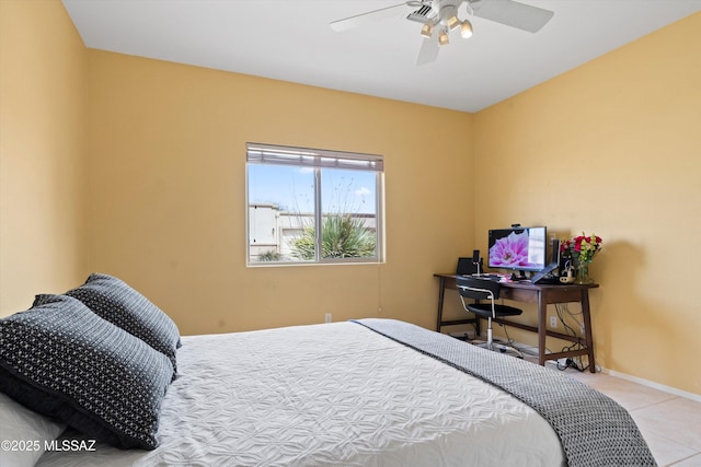 tiled bedroom featuring baseboards and a ceiling fan