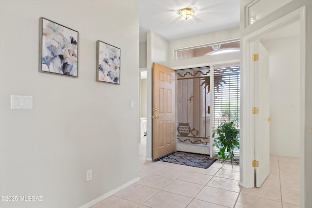 entrance foyer with baseboards and light tile patterned floors