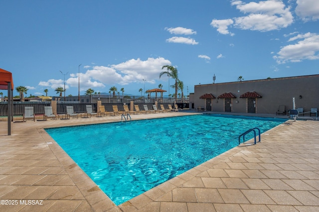 community pool with fence and a patio area