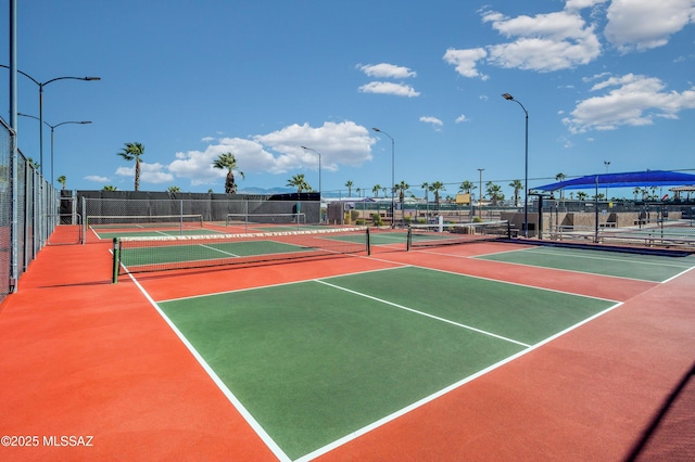 view of tennis court with community basketball court and fence