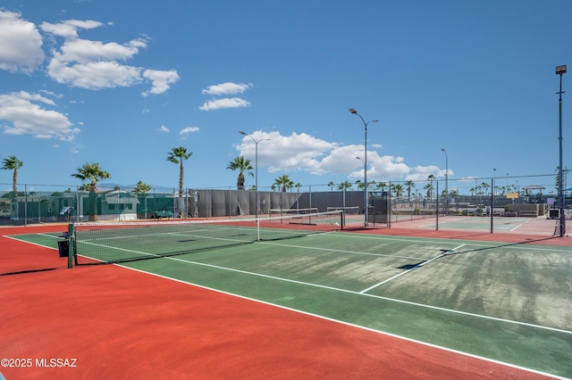 view of tennis court with community basketball court and fence