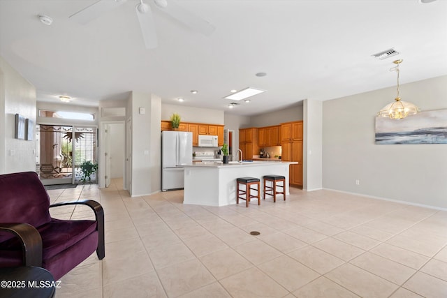 living room featuring light tile patterned flooring, baseboards, ceiling fan, and visible vents